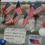 In memory of the Space Shuttle Columbia crewmembers who lost their lives on Feb. 1, mourners have placed signs, U.S. flags and flowers on the fences near the main entrance of the Johnson Space Center, Houston, Texas. NASA photo.