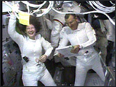 Astronauts Susan Helms, on the left, and Jim Voss go over a checklist as they prepare for their space walk. NASA image.