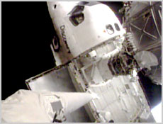 This view from Space Shuttle Discovery's robotic arm shows the space station's Pressurized Mating Adapter (center right) docked inside the shuttle's payload bay. NASA image.