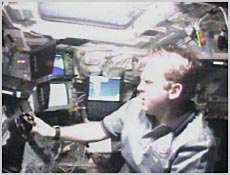 Mission Specialist Andy Thomas guides the shuttle's robotic arm toward Leonardo for removal from the station back to the shuttle's payload bay. NASA image.