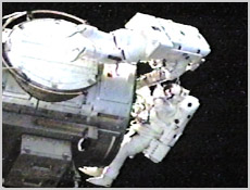 STS-105 Mission Specialists Dan Barry (top) and Pat Forrester install one of the two carriers used in the Materials International Space Station Experiment onto the space station's Quest Airlock. NASA image.