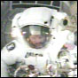 STS-110 Mission Specialist Steve Smith retrieves equipment from the Joint Airlock during the mission's third spacewalk. NASA image.