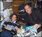 Astronauts Ellen Ochoa (left) and Michael J. Bloomfield eat a meal inside Space Shuttle Atlantis. NASA photo.