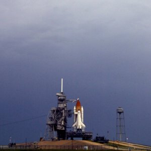 Storm clouds loom over Endeavour as she waits on the launch pad. NASA Photo KSC-02PD-0851, 31 May 2002.