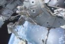 STS-112 astronaut David Wolf working outside the ISS, riding its robot arm. NASA TV capture.