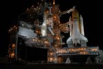 Lights brighten the night sky as the Rotating Service Structure is rolled away from the Space Shuttle.. Image credit: NASA/KSC