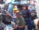 Expedition 11 and STS-114 crewmembers work in the Station's Destiny Laboratory. NASA TV image.