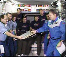 Expedition One Commander Bill Shepherd, on the right, gives the International Space Station's log book to Expedition Two Commander Yury Usachev during a change of command ceremony. NASA image.