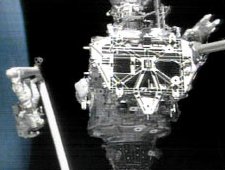 Mission Specialists Bill McArthur (attached to Discovery's robotic arm) and Leroy Chiao (in the top right corner) perform the first space walk of STS-92. They are working outside of the International Space Station's newest addition, the Z1 Truss. Image courtesy of NASA.