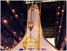 Space Shuttle Endeavour hangs suspended from a crane inside the Vehicle Assembly Building, waiting to be lifted into High Bay 1. Image courtesy of NASA.