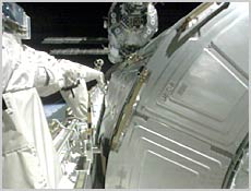 On the right, the U.S. Destiny Laboratory Module rests in Space Shuttle Atlantis' payload bay following the shuttle's docking with the International Space Station, which is visible in the background at the top. On the left is Atlantis' robotic arm, which will be used to attach Destiny to the space station on Saturday. NASA image.
