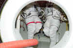 Extravehicular mobility suits (spacesuits) inside the Shuttle's airlock. NASA photo.